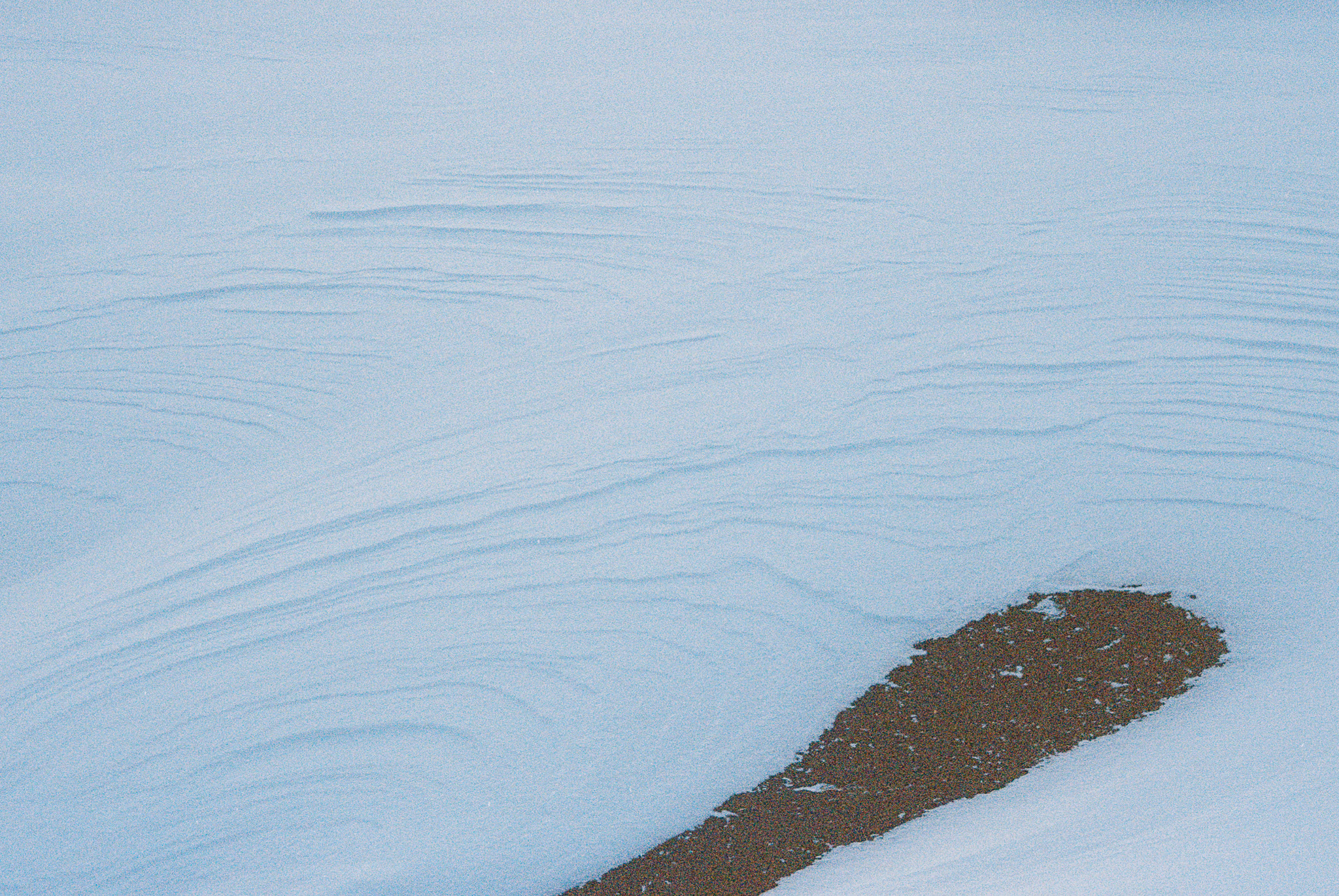 wind-blown snow on pavement